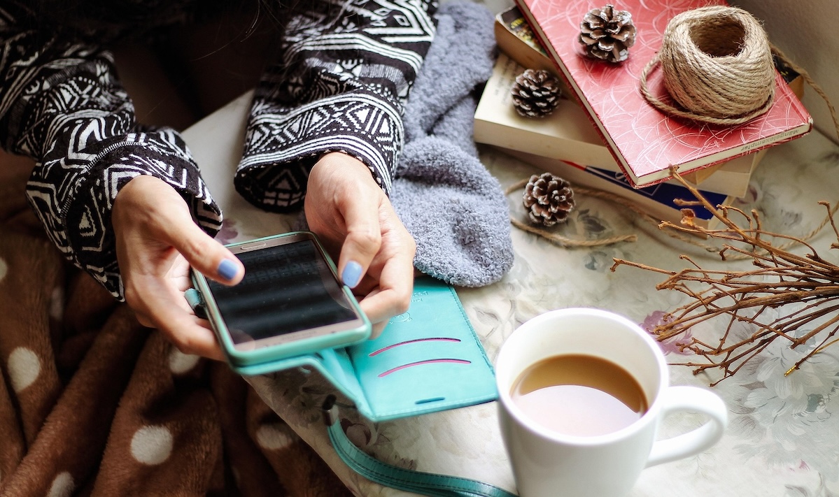 Smartphone in mano al tavolino di un bar: fatturare al volo con Gest-L Web mentre si beve il caffè